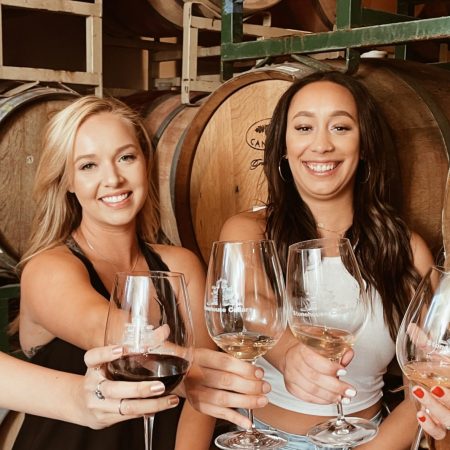 Four women drinking wine in the barrel room